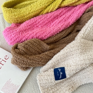 Detailed macro view of the fluffy lamb wool texture on a beige knitted scarf with a woven label