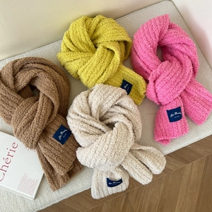 Detail of colorful plush scarves featuring soft lamb wool texture and brand woven labels