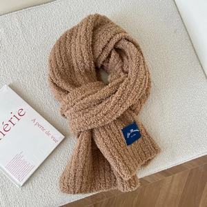Close-up of soft caramel brown teddy fleece scarf with a vintage navy blue brand woven label