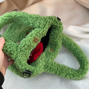 Detailed close-up of a green plush tote bag featuring a secure golden magnetic closure