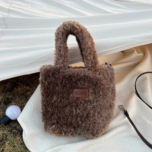 Detailed macro view of the brown plush faux fur bag with a leather HSNM brand label