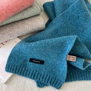Detailed macro view of 100% pure wool multi-colored flecked knit scarves with ribbed edges
