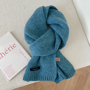 Detailed close-up of blue melange 100% wool knitted scarf with ribbed edge and soft texture