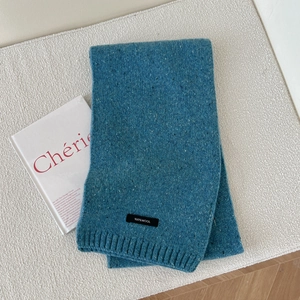 Detailed view of 100% wool knitted scarf in peacock blue with marled texture