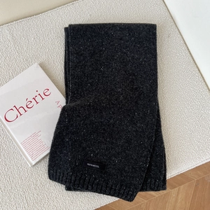 Detail of dark heather grey 100% wool scarf with subtle texture on woven background