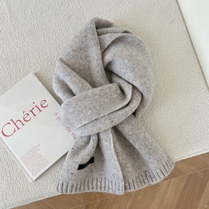 Close-up of grey knit wool scarf texture with colorful nepps and ribbed edge details
