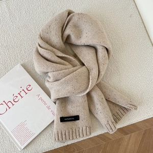 Detail showing 100% wool label on oatmeal cable knit scarf with colorful flecks