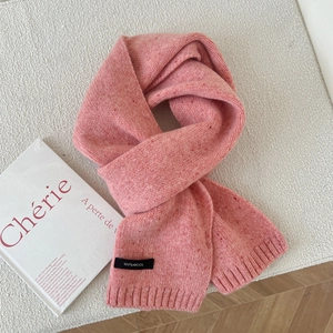 Detail of 100% wool knit scarf in soft pink showing the thick ribbed texture and brand label