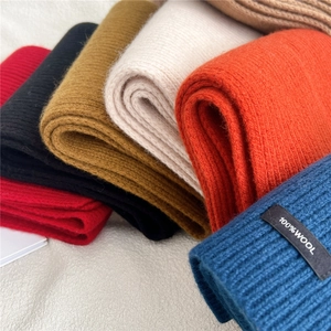 Detailed close-up of 100% pure wool knitted scarves in multiple vibrant winter colors
