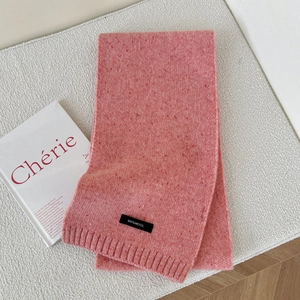 Detail of 100% wool knitted scarf showing texture and material certification label