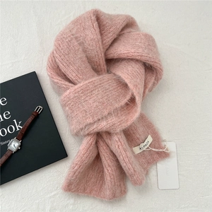 Detail of pink knitted alpaca wool scarf showing soft fluffy texture and brand tag