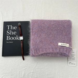 Close-up of purple alpaca wool knit scarf with soft plush texture and care label