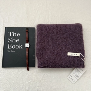 Detailed view of dark purple alpaca knit scarf with a vintage leather strap watch