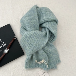 Detail of light blue alpaca knit scarf with visible soft texture and washing label