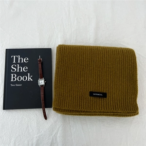 Detailed macro view showing the 100% pure wool texture and wash label of the knitted scarf