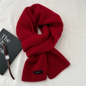 Detail view of 100% wool knitted scarf with ribbed texture and material care label