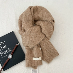 Detailed close-up of warm alpaca wool blend knit scarf with brand material tags