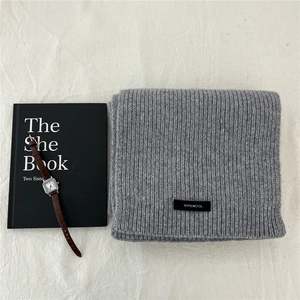 Detail shot of 100% pure wool scarf with thick ribbed knit texture and soft gray finish