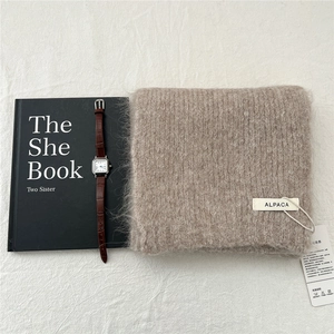 Detailed texture of knit alpaca wool scarf in beige with a premium lifestyle layout
