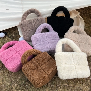 Plush faux shearling handbag with quilted design in seven colors on a natural lawn