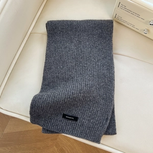 Close-up of thick dark grey 100% pure wool knitted scarf with a focus on fabric texture