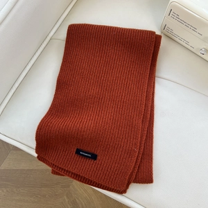Detail of caramel knit wool scarf showing premium ribbed texture and 100% wool material
