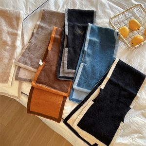 Écharpes en tricot de couleurs variées avec bordure contrastée sur fond de lit blanc
