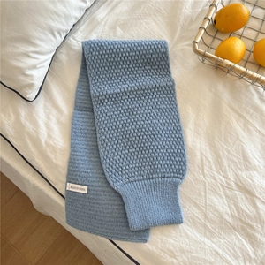 Detail of light blue honeycomb knit scarf showing texture and ribbed cuff design