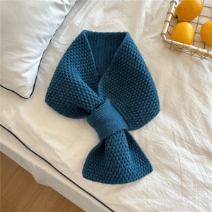 Close-up of deep blue chunky knit scarf with a practical cross-over slit design