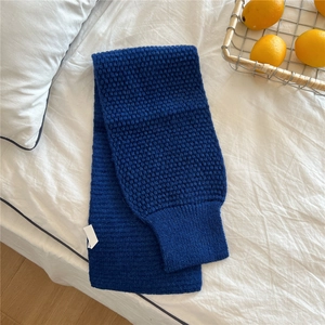 Detailed knit texture of royal blue winter scarf on a cozy white home setting