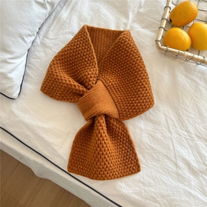 Detail of caramel chunky knit scarf with honeycomb texture and cross-over fastening