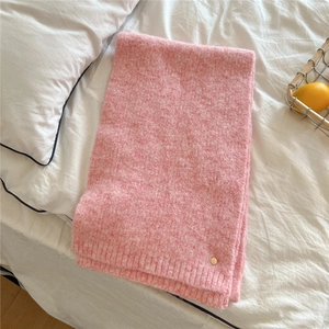 Detail of pink knitted scarf with soft fluffy texture and gold metal rivet decoration
