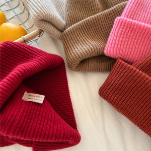 Flat lay of 100% pure wool ribbed knit beanies in multiple warm winter colors