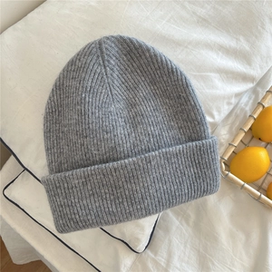 Detail of gray ribbed knit beanie with soft texture on a cozy white background