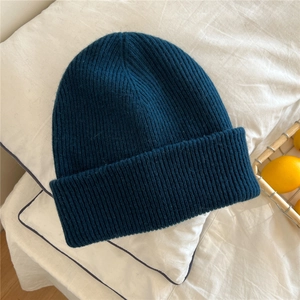 Detail of teal blue ribbed knit beanie showing soft texture and wide cuff design