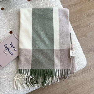 Close-up of 100% wool plaid scarf in forest green and beige with fringe details