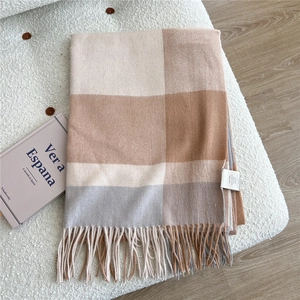 Close-up of 100% cashmere scarf with beige, camel, and grey color-blocking and fringe