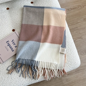Detailed view of 100% wool scarf with large plaid pattern and elegant tassels