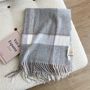 Detail of 100% wool scarf showing classic grey plaid pattern and delicate fringe trim