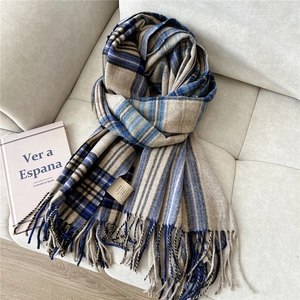 Detail of 100% cashmere scarf label and fringed edge on a classic plaid winter wrap