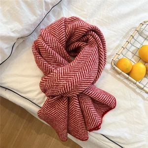 Close-up of red and white herringbone knit scarf texture with a warm cozy feel