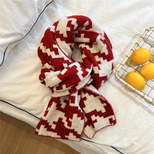Detail of red and cream houndstooth knit scarf with thick warm wool texture