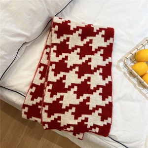 Detail of red and white houndstooth knit scarf with soft cashmere-like thick texture