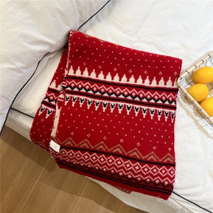 Detail of red festive knit scarf featuring Fair Isle patterns with white cedar trees