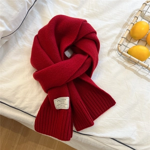 Detail shot of 100% pure wool red scarf featuring a high-quality ribbed knit texture
