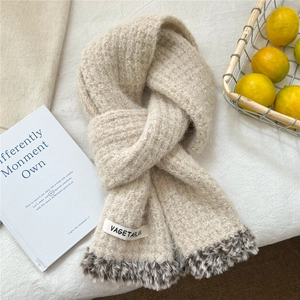 Detail of beige knit scarf featuring leopard print faux fur trim and woven brand label