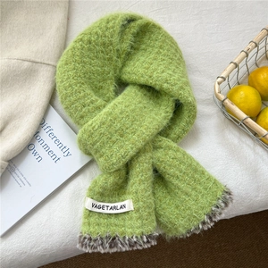 Detail of grass green knitted scarf with leopard print faux fur trim and white woven label