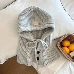 Detail of light gray knitted balaclava hood featuring black buttons and adjustable drawstring