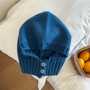 Dettaglio del passamontagna blu navy in maglia con bottoni decorativi e trama a coste
