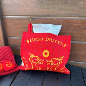 Detail of red knitted lucky dragon tissue box cover with decorative coin patterns